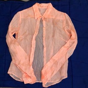 Sheer peach shirt with fancy buttons.